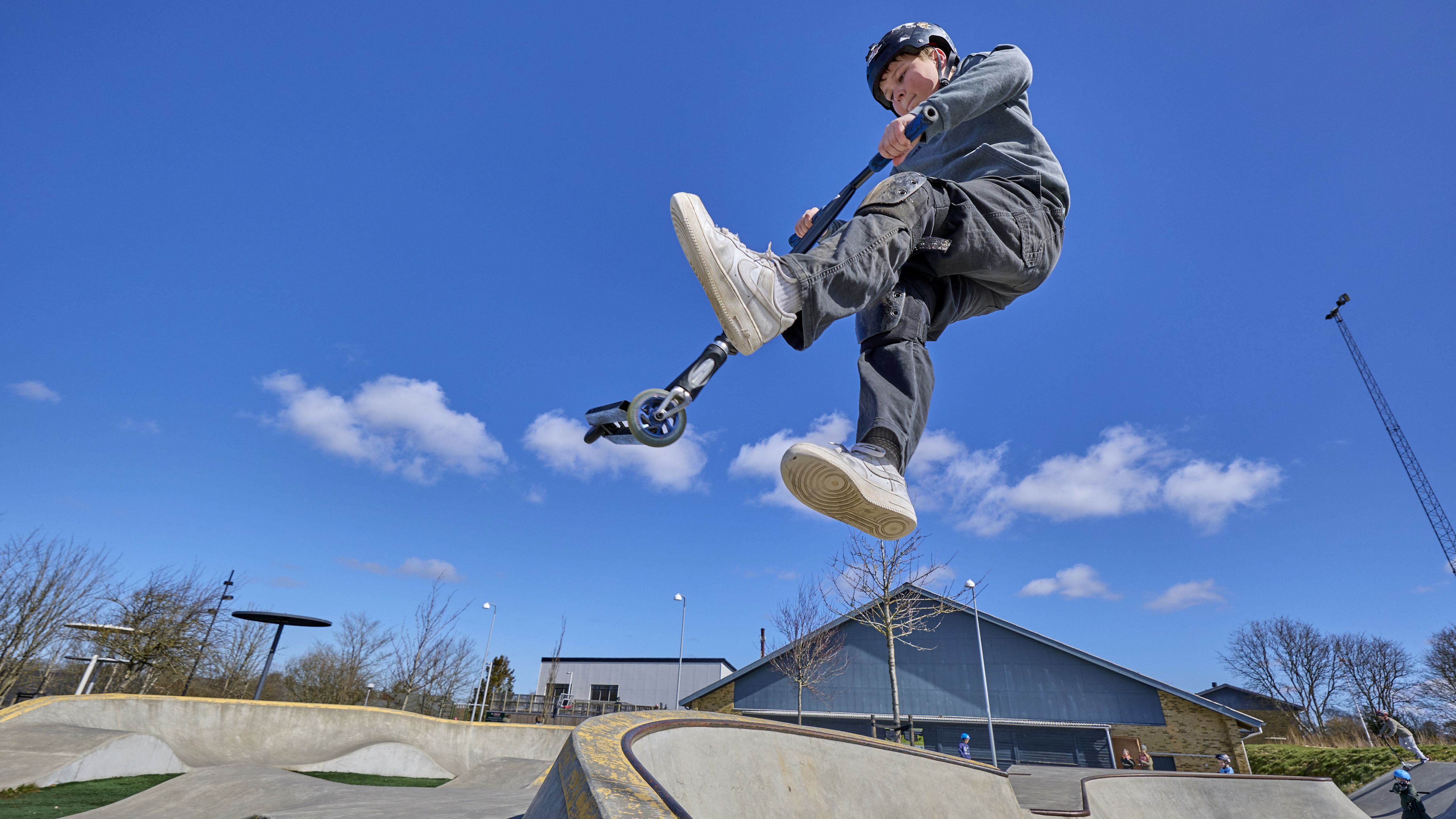Dreng på løbehjul i skaterpark